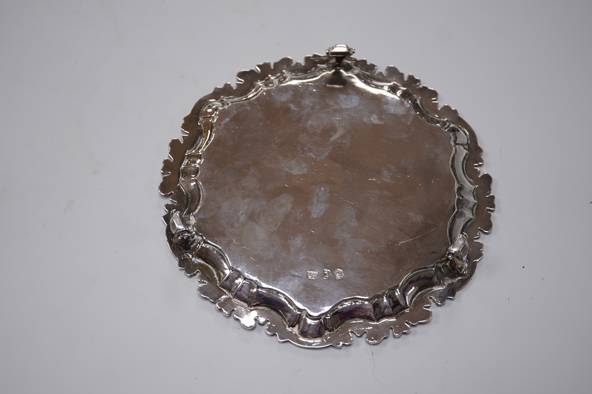 A George II silver card waiter, (with Howard Tripp crest?), of shaped circular form, on three scroll feet, maker's mark rubbed, London, 1740, 17.9cm, 9.4oz.